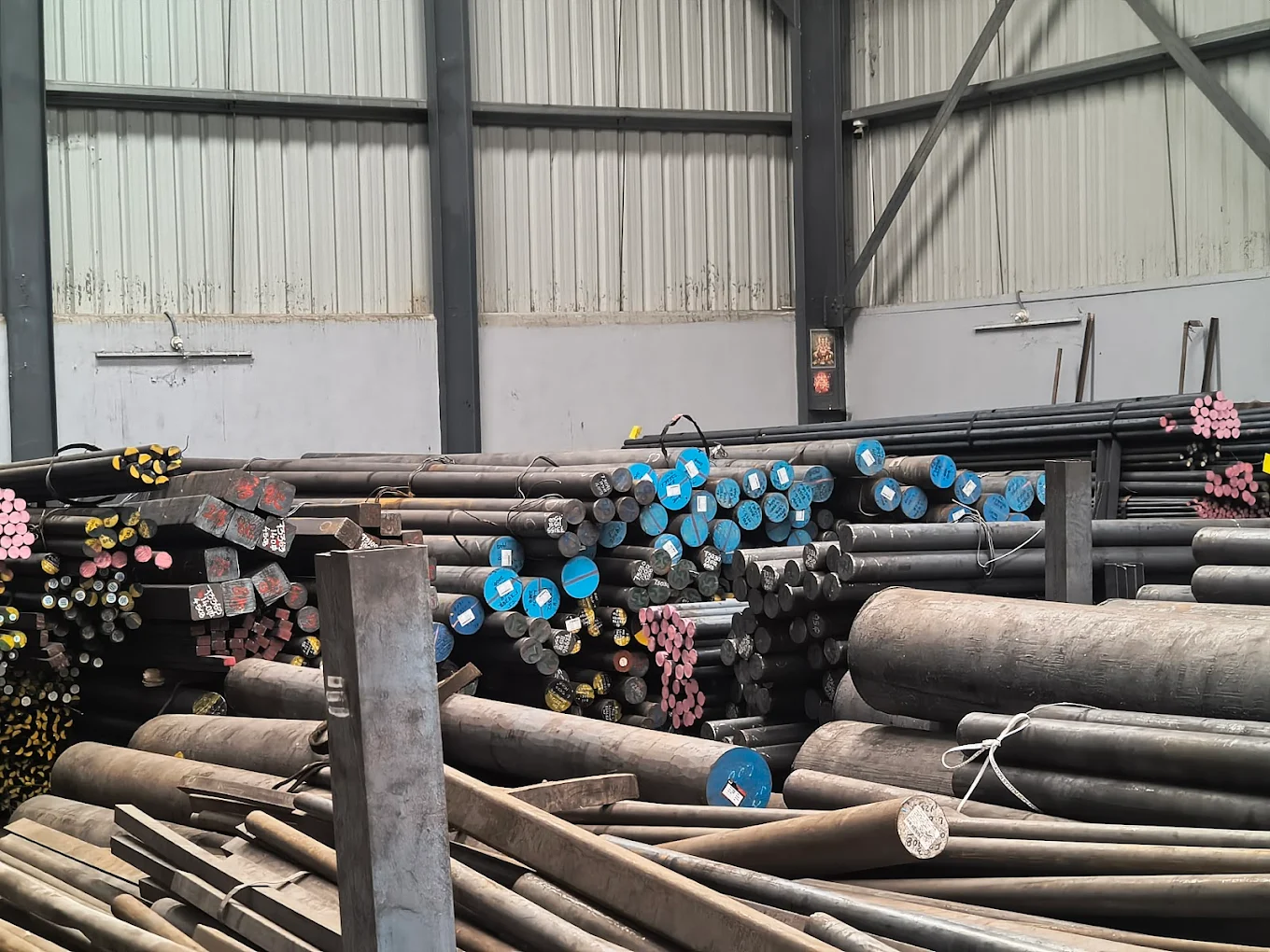 Blue-tagged steel round bars in storage